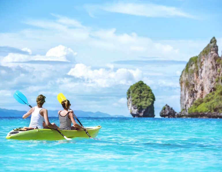 Two ladies are kayaking or kanoeing at beautuful tropical lagoon at Phi-Phi islands. Krabi province, Thailand